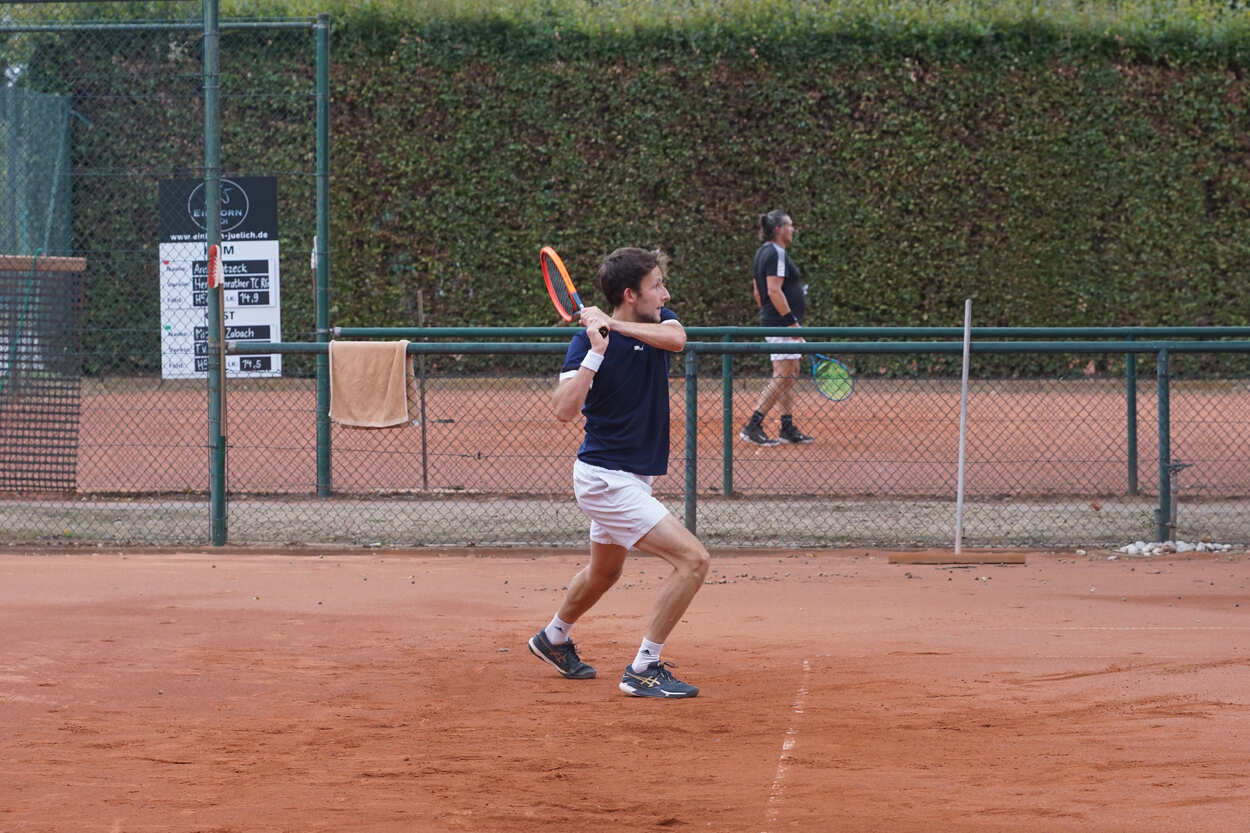 Zwei Tennissplätze nebeneinander, auf beiden ist ein männlicher Spieler zu sehen.