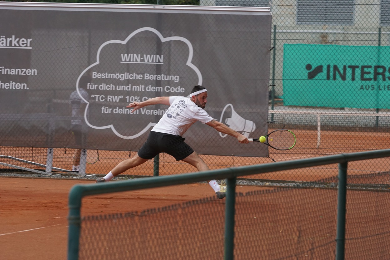Junger Mann steckt sich zu einem Tennisschlag